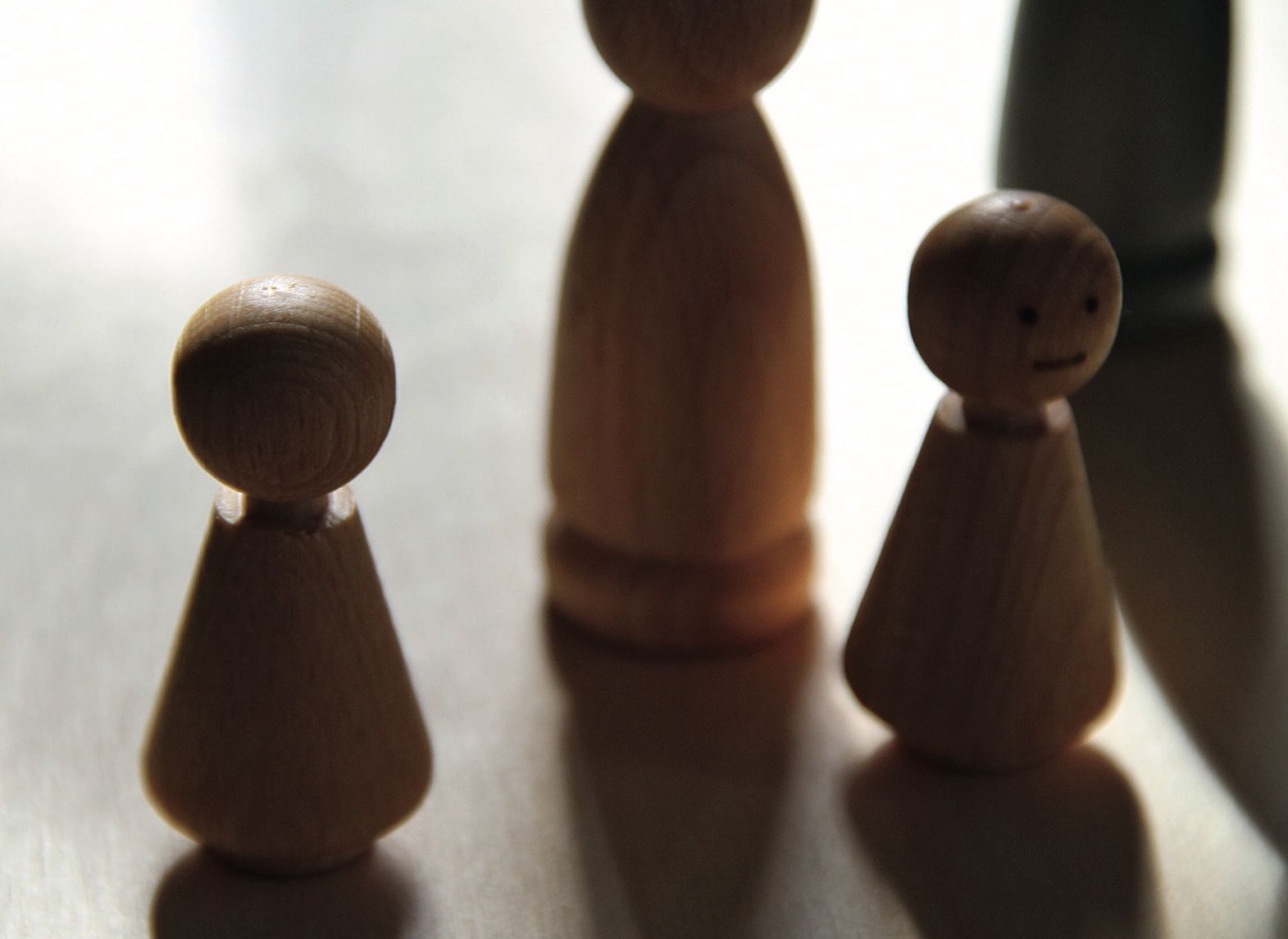 Holzfiguren eines Familienbretts stehen auf einem Tisch