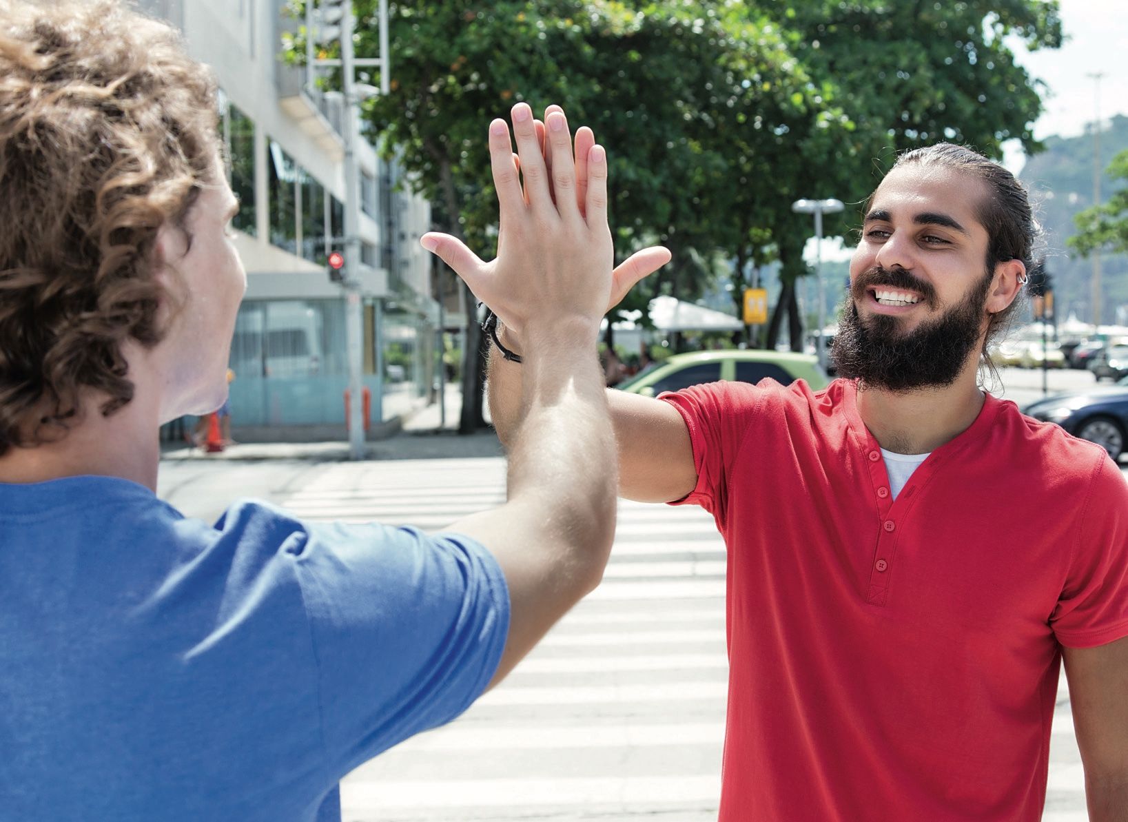 Zwei junge Männer geben sich auf der Straße ein High Five